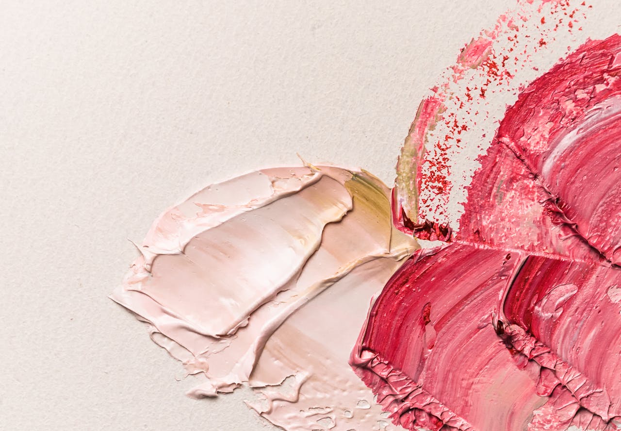 Abstract oil paint textures on canvas with vibrant red and pink tones.